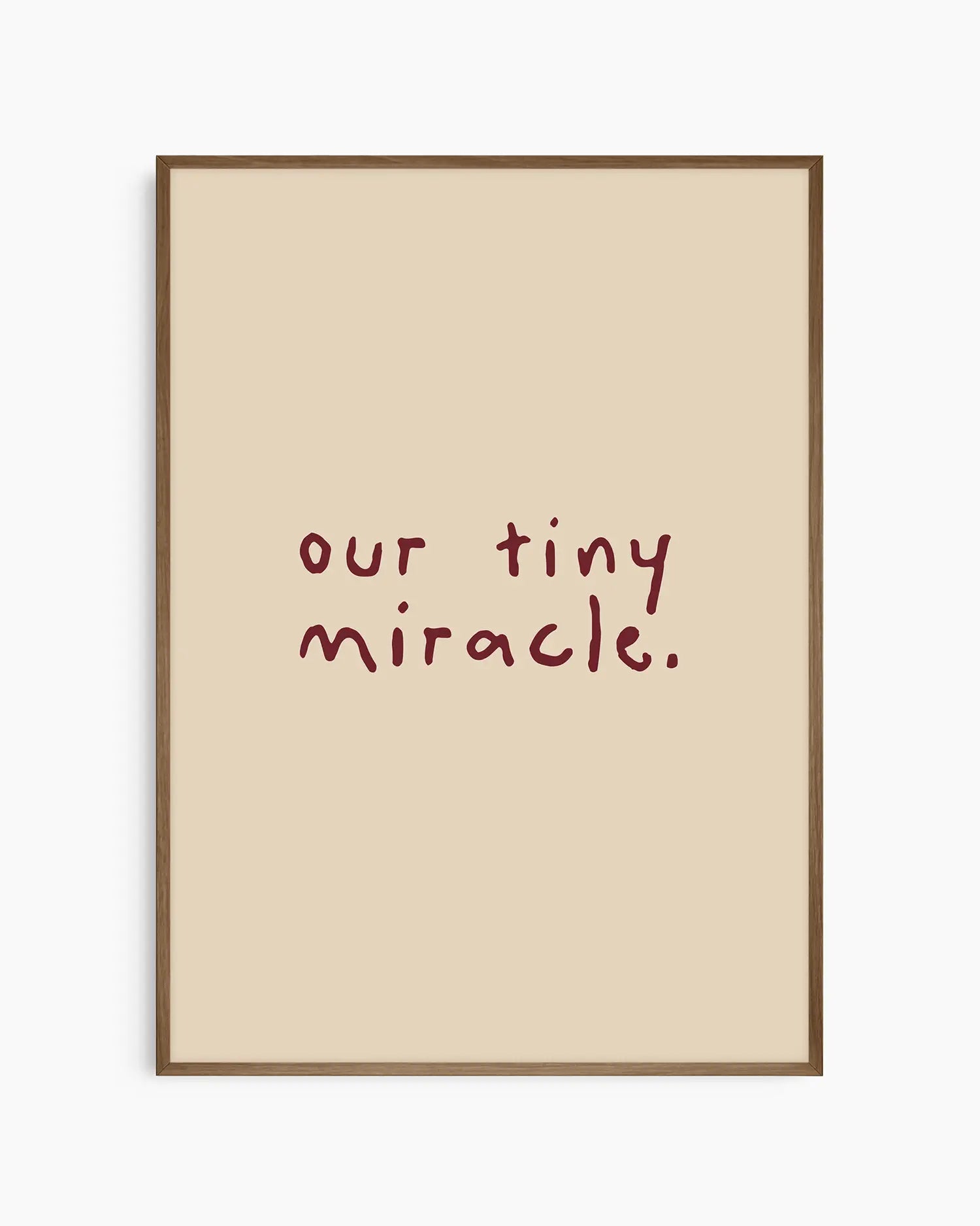 Beige nursery poster with 'our tiny miracle.' text in brown framed in a dark oak frame.