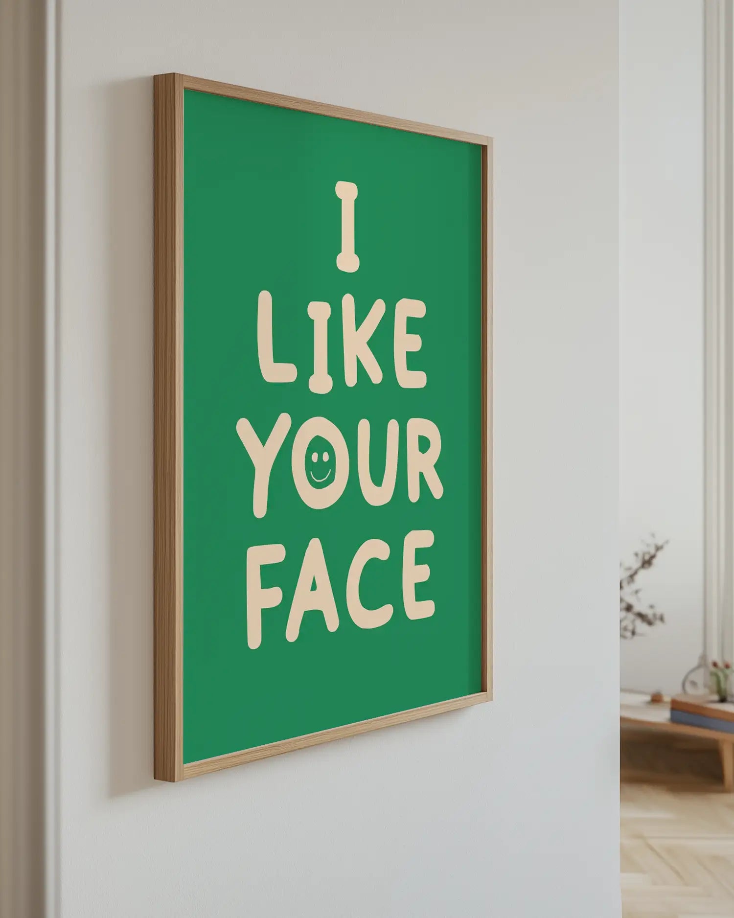 Green artwork with 'I Like Your Face' text, mounted on a wall.