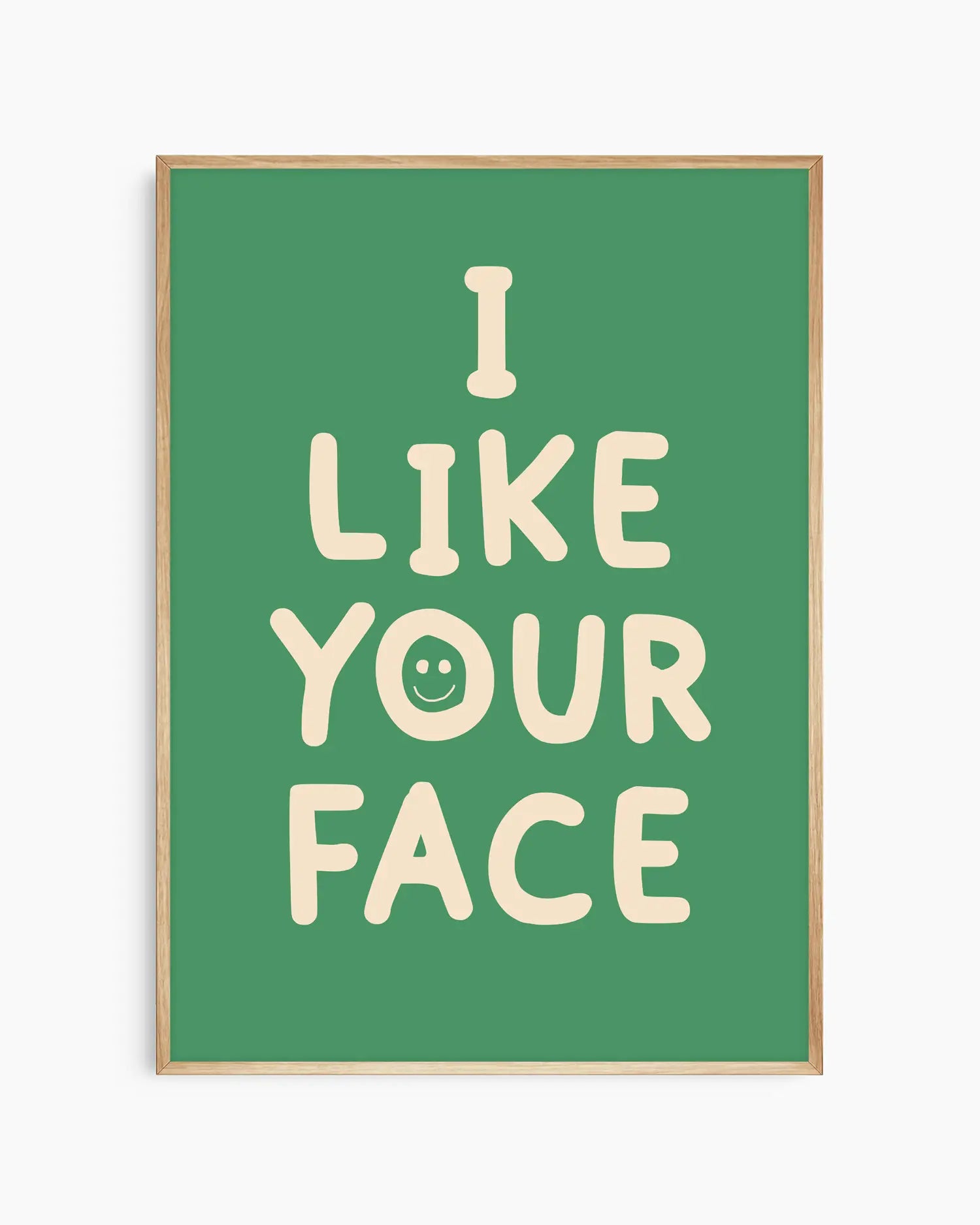 Green nursery poster with the text 'I like your face' written in beige, framed in an oak frame.