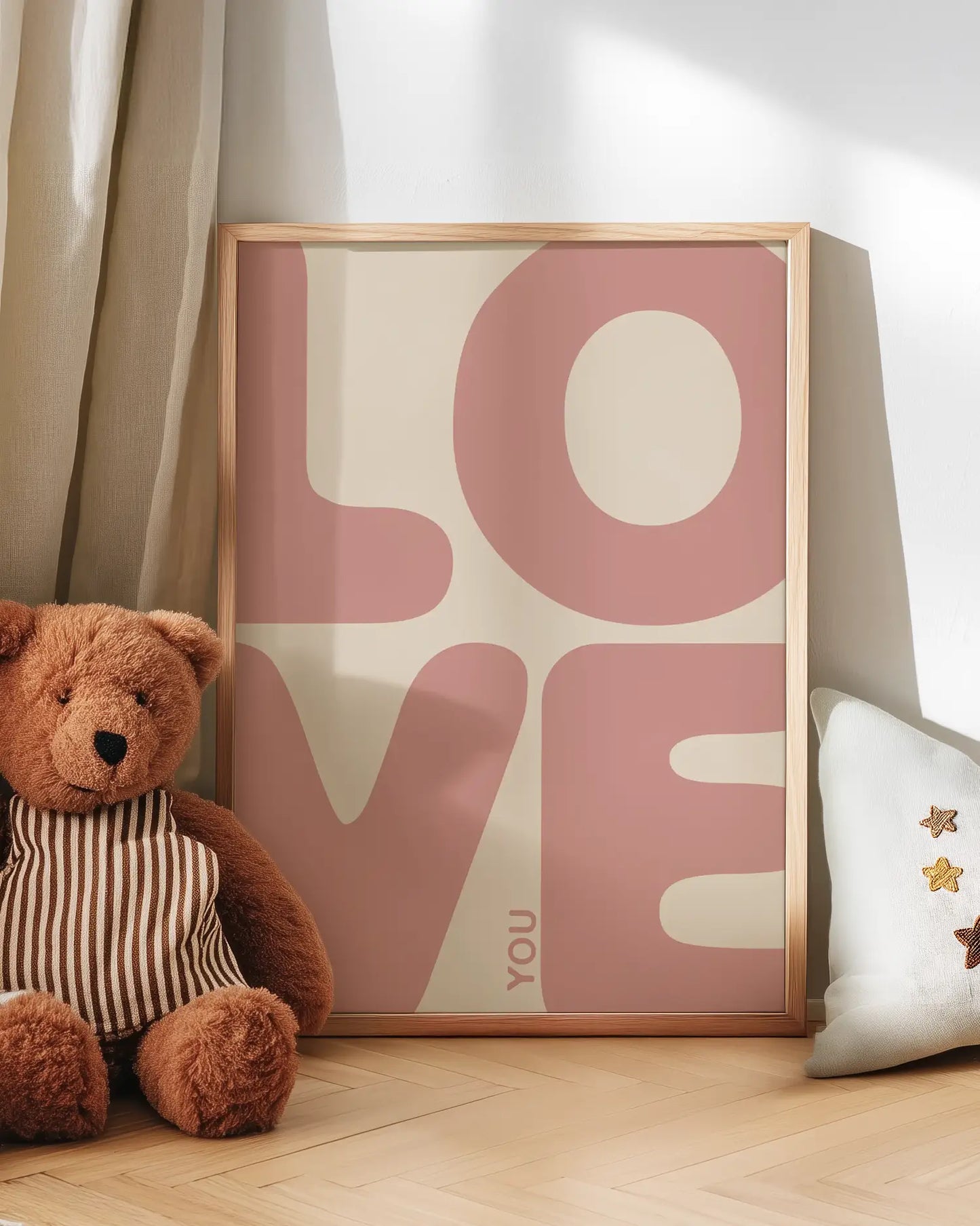 Teddy bear next to a poster with 'LOVE YOU' text on a wooden floor.