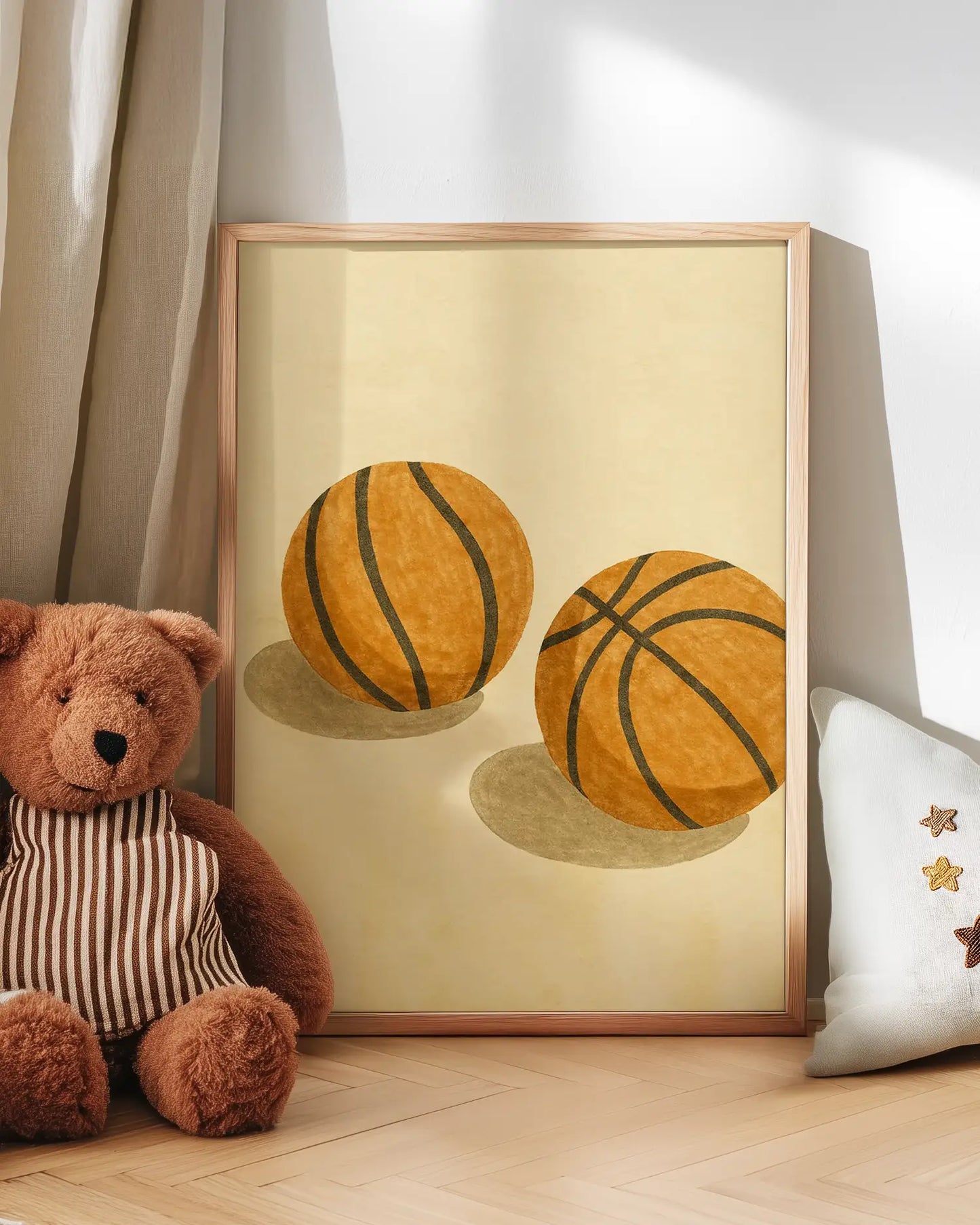 Artwork of two basketballs on a beige background with a teddy bear and decorative pillow in the foreground.