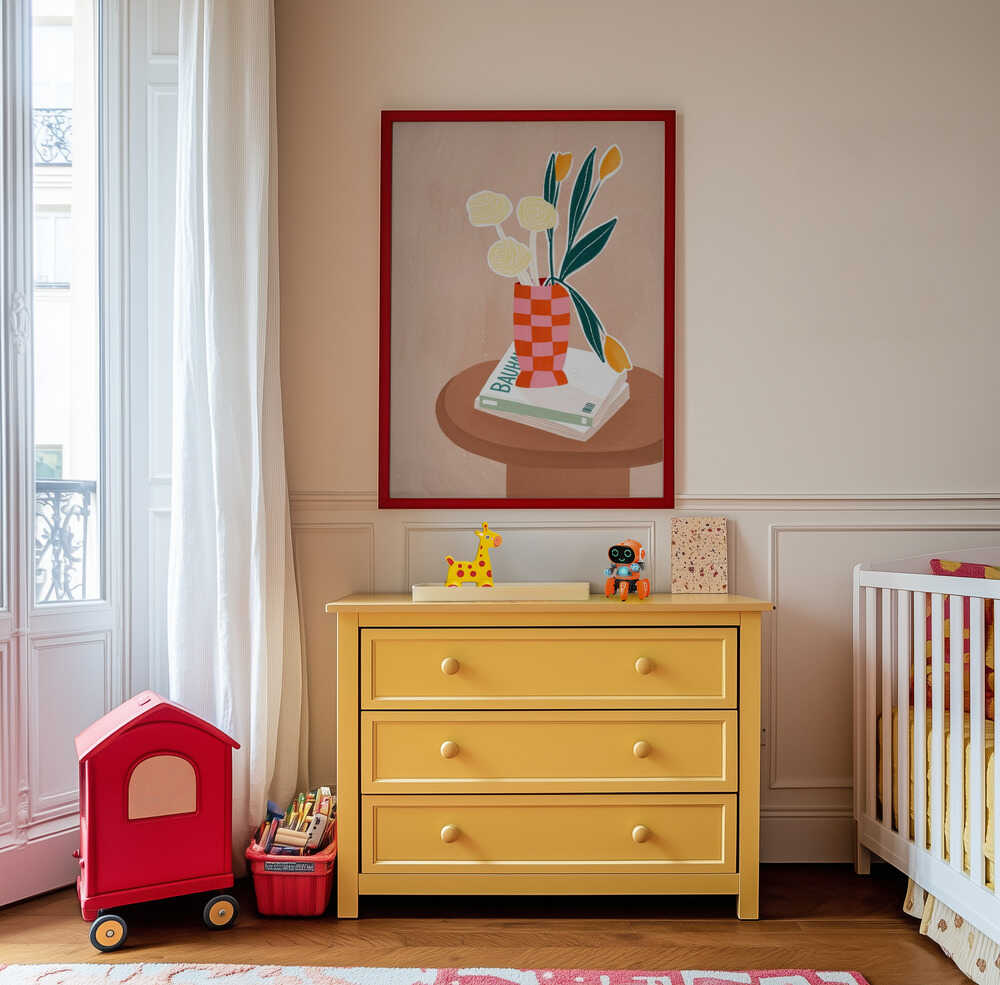 Beige poster with a brown side table with books on top and a pink and orange checkered vase with yellow flowers inside hanging on the wall in the children's room