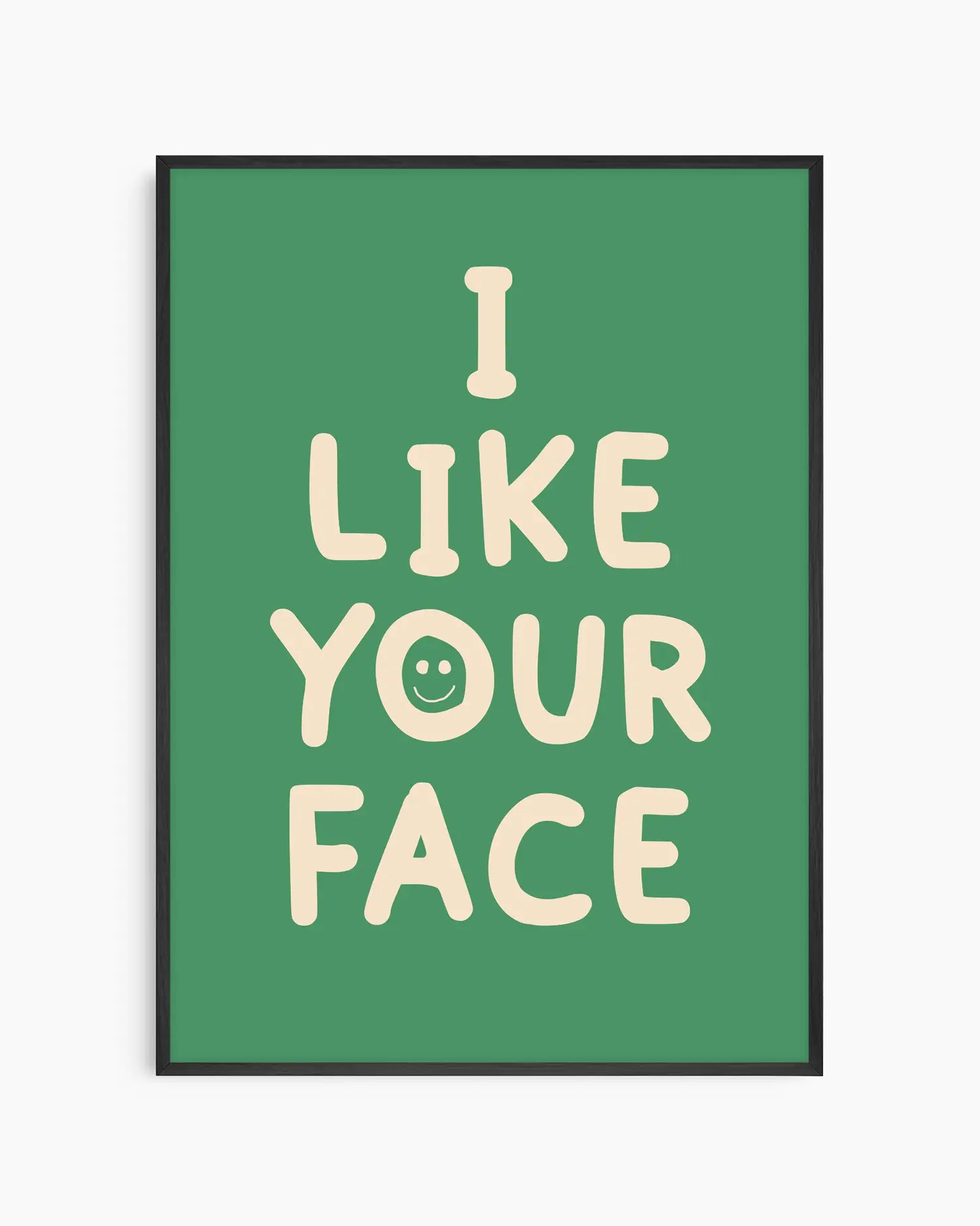 Green nursery poster with the text 'I like your face' written in beige, framed in a black frame.