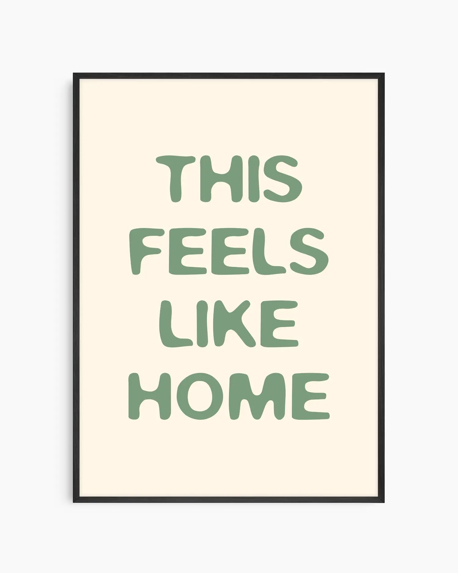 Nursery poster with the text 'This feels like home' written in green, inserted in an black frame