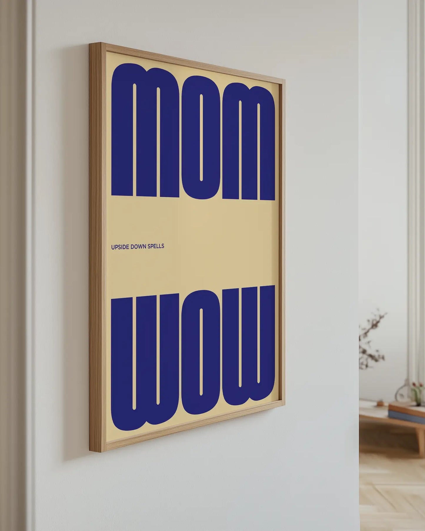 Artwork with 'MOM upside down spells WOW' in blue text hanging on the wall.