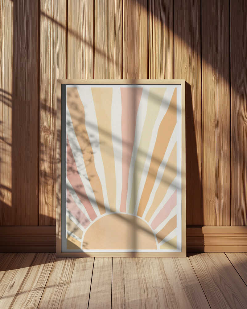Warm sunrise art print featuring abstract sun rays in soft pastel tones of yellow, beige, and blush pink. Displayed in a light wooden frame leaning against a wooden wall with gentle sunlight and shadows. Minimalist boho wall art perfect for modern Scandinavian interiors.